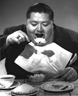 Spooning: Heavy Set Man Spooning Desert Down With More on the Table