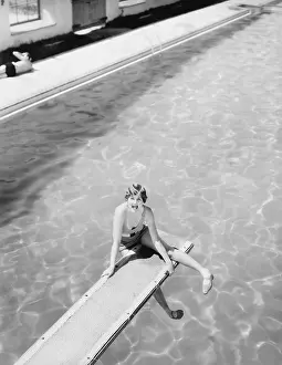 Scream: High angle view of a woman sitting on a diving board