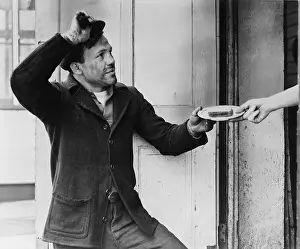 Handouts: A Hobo, Lou Ambers, tips his hat as he accepts ?