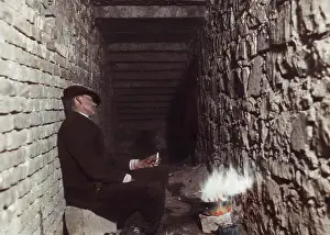 Sewerage: Homeless person sitting by the fire