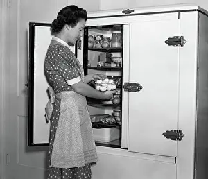 Iceboxes: Housewife in apron taking eggs out of bowl from