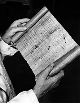 Restorer: Hugo Ibscher holds a papyrus document in roll form, 1934