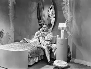 Coquettishness: Husband and wife embracing on a bed