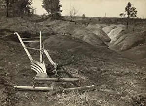 Recessions: An idle plow on farm land adjacent to eroded ?