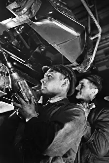 Nuts: Industrial workers assembling an engine