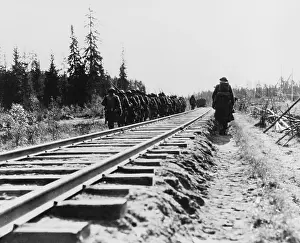 East Asia: US Infantry, marching along railway lines during
