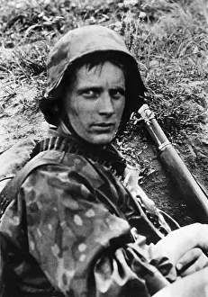Rests: Infantryman rests in his trench, WW2