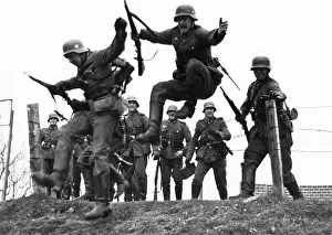 Hopping: Infantrymen jump over a fence