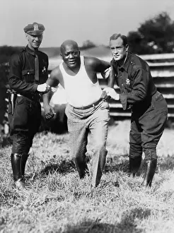 Heavyweights: Jack Johnson, being held by two police officers