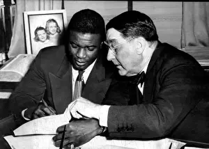 Rickey: Jackie Robinson (left), being signed by ?