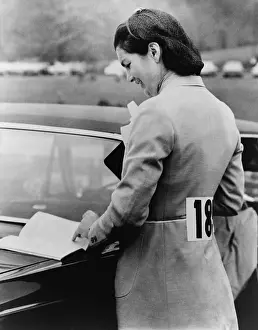 Equestrians: Jacqueline Kennedy, reading book lying on ?