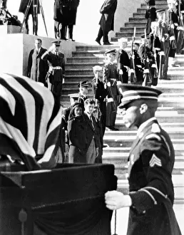 Csualpha: Jacqueline Kennedy, in a widow's veil, watches ?