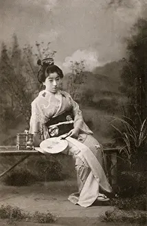 Courtesans: A Japanese Geisha posing in a studio garden setting