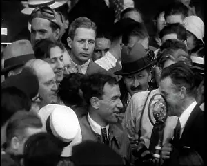 Mollison: Jim Mollison Walking Surrounded by a Large Crowd