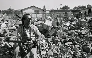 Joao Silva sitting amongst building rubble, cameras