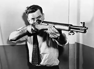 Garand: John C. Garand (1888-1974), aiming one of ?