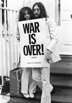 Lennon: John Lennon and Yoko Ono with War Is Over poster