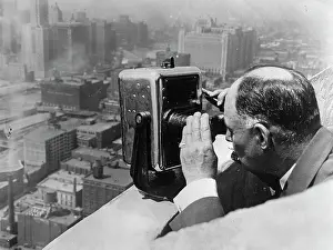 Dime: John S. Fee looks by a dime binoculars