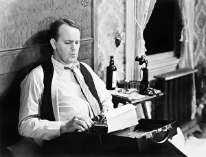 Employ: Journalist sitting on his bed with a typewriter, typing