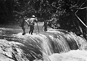 Troublesome: Jungle explorers crossing a river, 1935