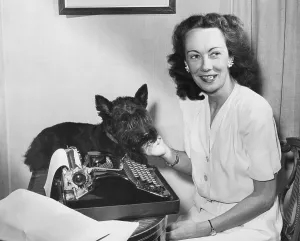 1295: Kay Summersby at her typewriter with her pet scottie