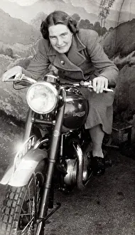 Crouched: Lady on a 1948 Triumph motorcycle