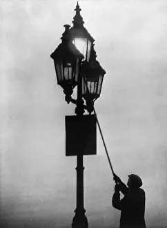 Professions: A lamplighter at work in the London fog