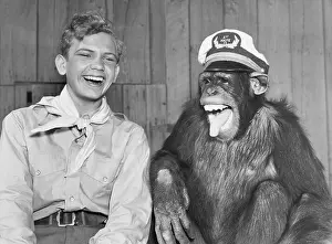 Teenaged: Laughing boy scout and monkey wearing hat