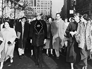 Fads: A laughing crowd accompany a man dressed ?