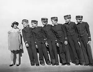 Teenaged: Line of young bellhops smiling at girl