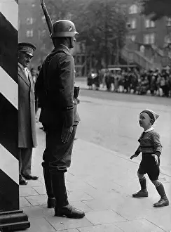 Reached: Little boy admires a guard, 1936
