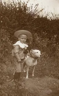 Studded: Little boy with a bull terrier in a garden