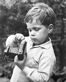 Concertina: Little boy with a camera in a garden