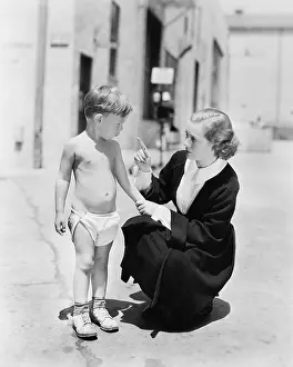 Scolded: Little boy in diapers getting scolded by his mother