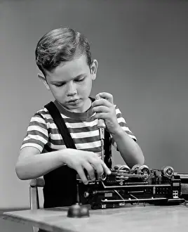 Screwdriver: Little boy fixing lionel electric toy train engine