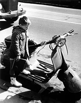 Mopeds: A little boy leaning on