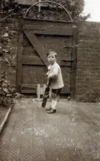 Backyard: Little boy practising cricket in the back yard