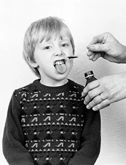 Disgusted: Little boy reluctantly taking his medicine