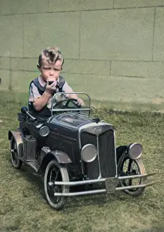Headlamps: Little boy sitting in a toy car