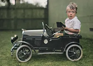 Headlamps: Little boy sitting in a toy car