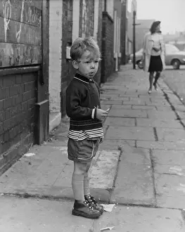 Gazing: Little boy standing on a pavement