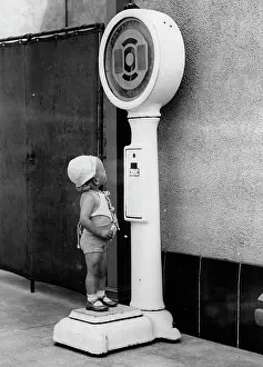 Dieting: A little boy is standing on the scales