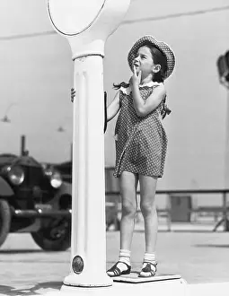 Startle: Little girl looking confused by a scale