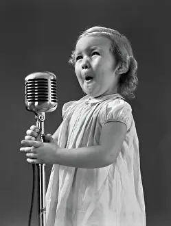 Audition: Little girl making face singing into microphone