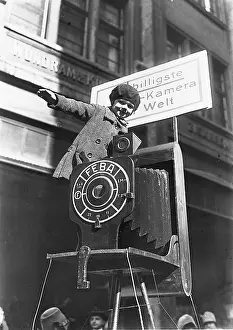 Cheapest: Little Girl sitting on an oversized camera