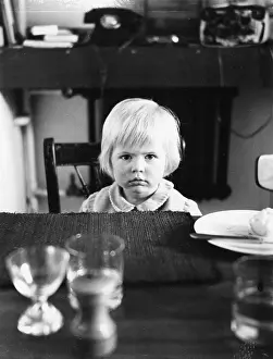 Puzzled: Little girl sitting at a table