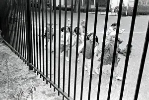 Multiracial: Looking through a railing fence at a group of