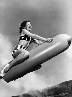 Midair: Low angle view of a young woman sitting on a rocket