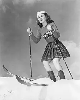 Cheerfulness: Low angle view of young woman skiing