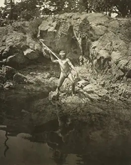 Spearing: Lummi man aiming his spear at a salmon in